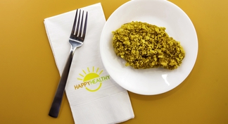 fork, napkin, and plate with single piece of baked chicken with golden crust