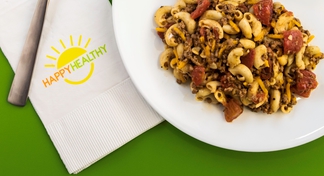 shallow bowl beefy macroni and cheese beside napkin