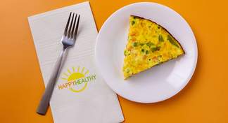 Slice of Anytime Egg Skillet on white plate next to HappyHealthy napkin and fork