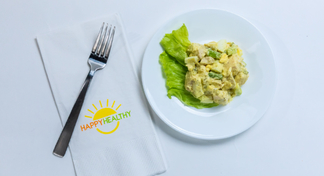 Chicken Salad on a plate with a fork on a HappyHealthy napkin.
