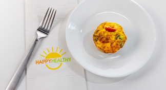 A plate with an egg muffin next to a fork with a HappyHealthy napkin