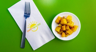 Plate of glazed butternut squash beside napkin and fork.
