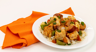 A plate of One Pan Jambalaya next to an orange napkin