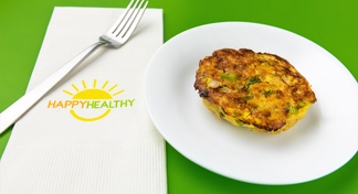 Salmon Patty on white plate next to HappyHealthy napkin and fork