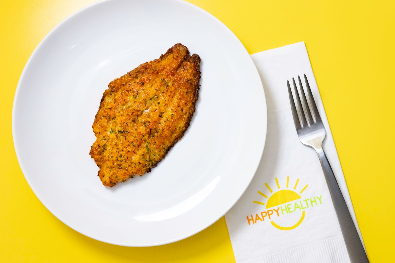 A white plate with Parmesan Crusted Catfish